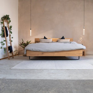 Massivholzbett aus Eiche mit Metallkufen, minimalistisch im Design. Perfekt kombiniert mit Naturmaterialien für ein stilvolles Schlafzimmer.