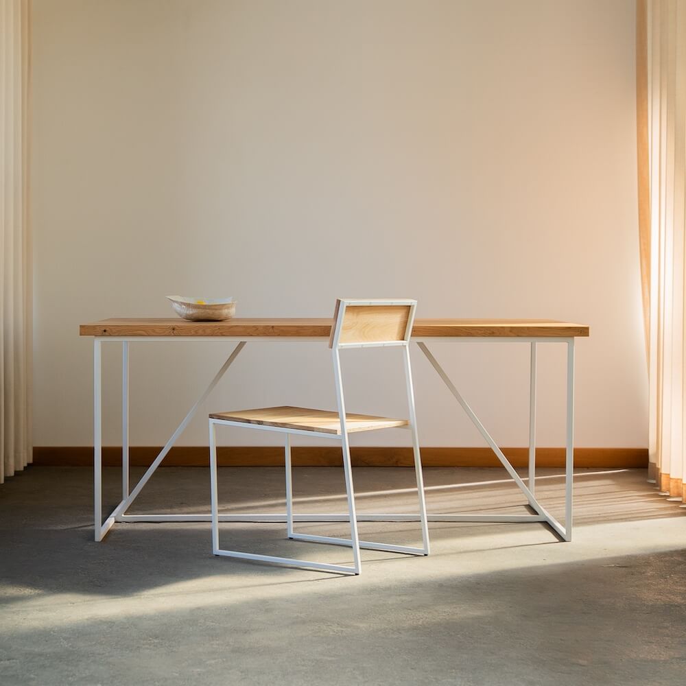 Esszimmerstuhl MILO aus Eiche mit weißem Stahlgestell an Designertisch aus Massivholz vor Vorhängen