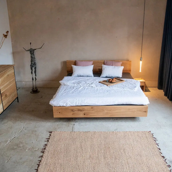 Massivholzbett Eiche Industrial, Metallfüße, Design Schlafzimmer mit Kommode, Teppich und Hängeleuchte.