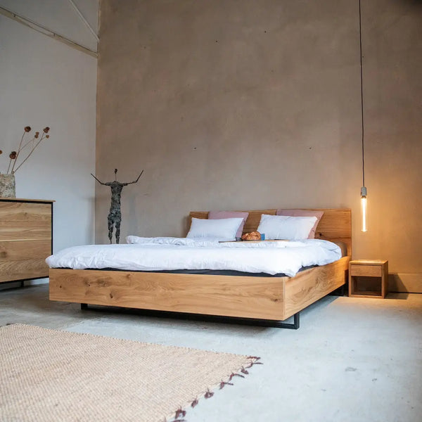 Massivholzbett Eiche mit Metallfüßen, Industrial Design, Holzkommode, Teppich, Hängeleuchte.