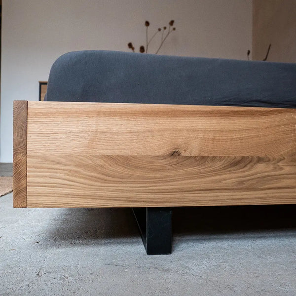 Massivholzbett aus Eiche mit Kufengestell, minimalistisches Design mit natürlicher Holzmaserung.