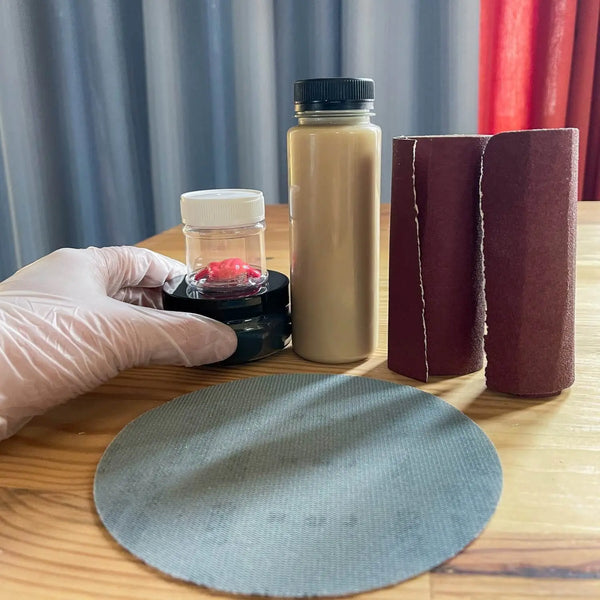 Reparaturset für Massivholzmöbel mit Schleifpapier, Holzpaste, Öl und Wachs zur Pflege und Ausbesserung von Kratzern und Dellen in Holzoberflächen.