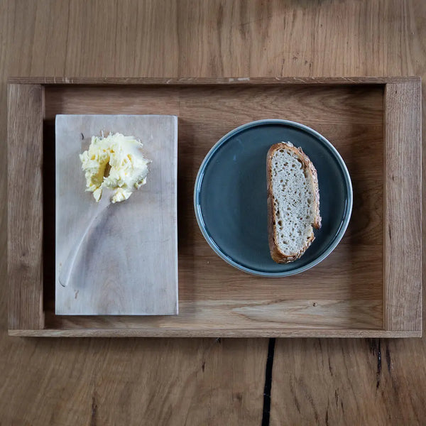 Serviertablett aus Eiche mit Butterbrett und Brot auf Keramikteller – hochwertiges, nachhaltiges Holzdesign für Küche und Essbereich.